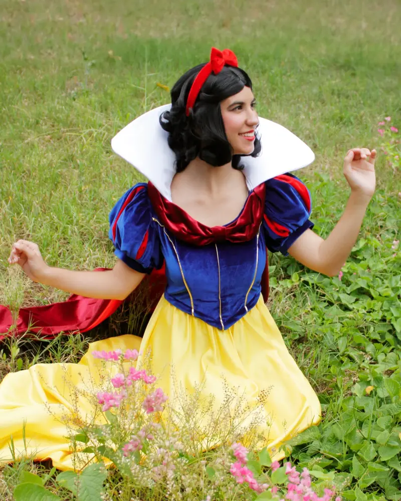 Blancanieves sentada entre la hierba y las flores