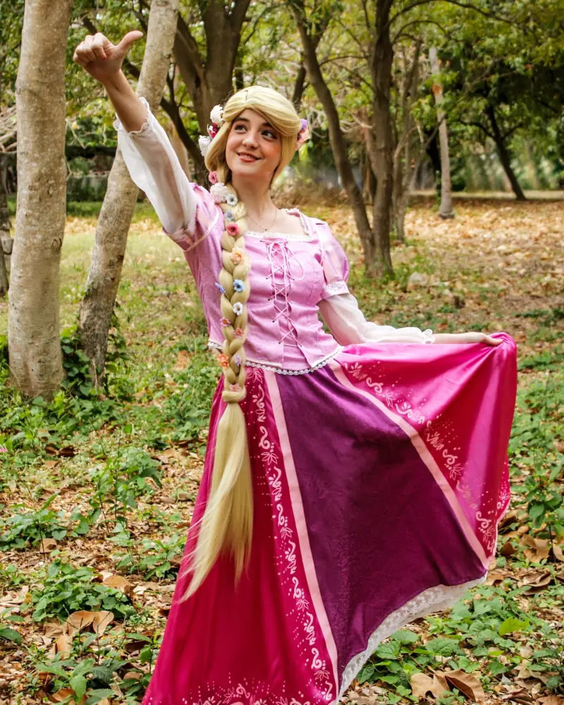 Rapunzel con su vestido lila entre las flores del jardín